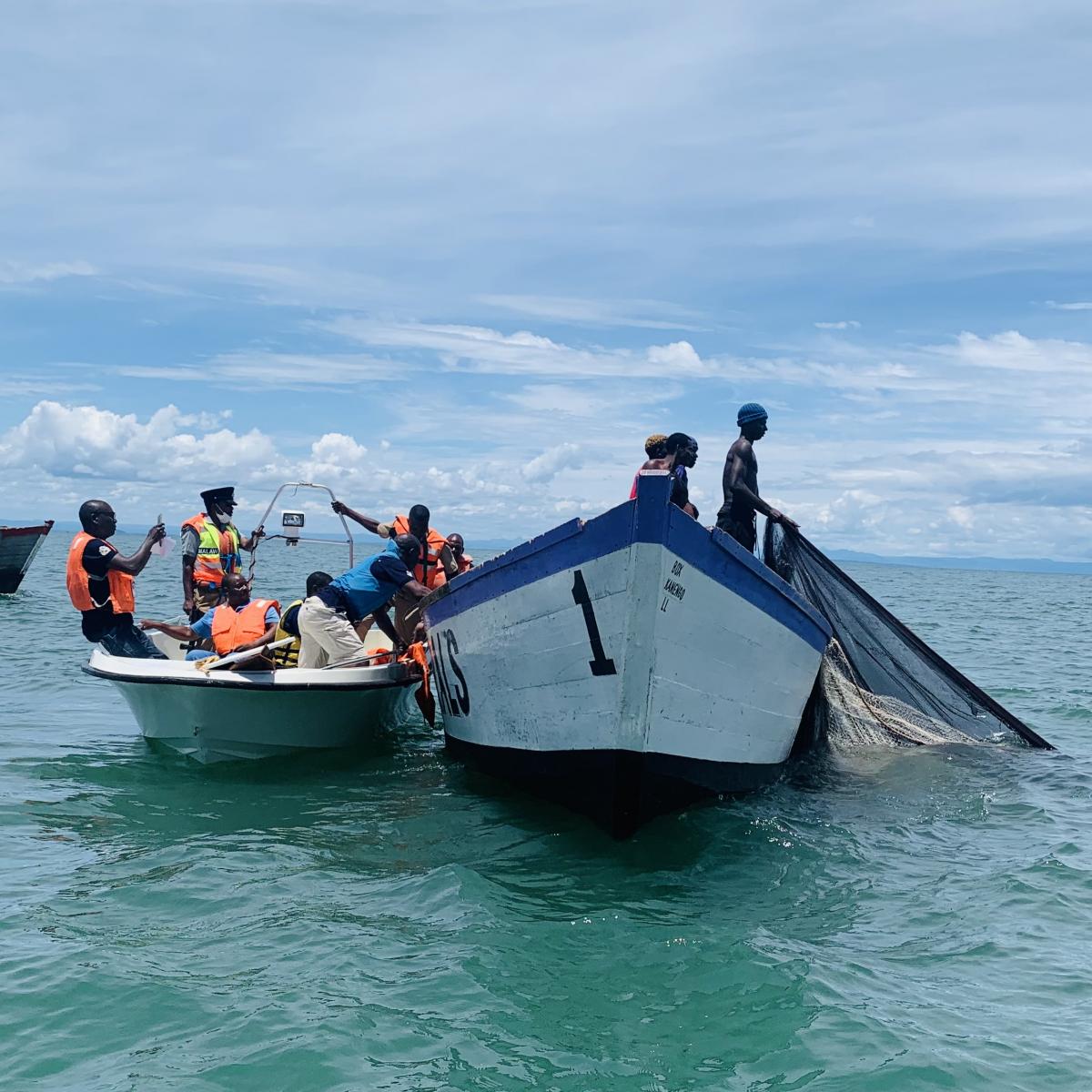 A scene on Lake Malawi of law enforcers arresting illegal fishers and at the same time, confiscating their boat and fishing nets. 