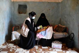 A USAID-trained midwife provides health services to a mother and baby.