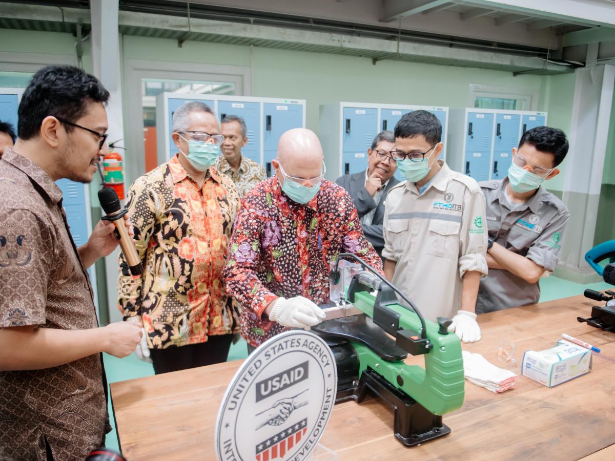 USAID Indonesia Mission Director Jeff Cohen is trying a wood working tool at Maker Innovation Space with students and faculty members of ITB