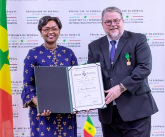 Retiring USAID/Senegal Mission Director Peter Trenchard receives Senegal's highest civilian honor-- the Officier de l'Ordre de Lion-- from Minister of Economy and Planning Oulimata Sarr.