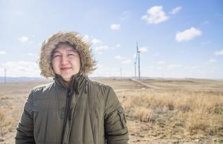 A man smiling in front of wind turbines