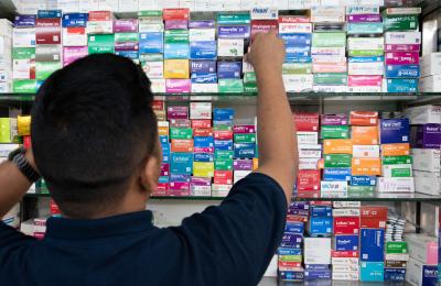 A man stocks a pharmacy with quality medicines in Bangladesh.jpg