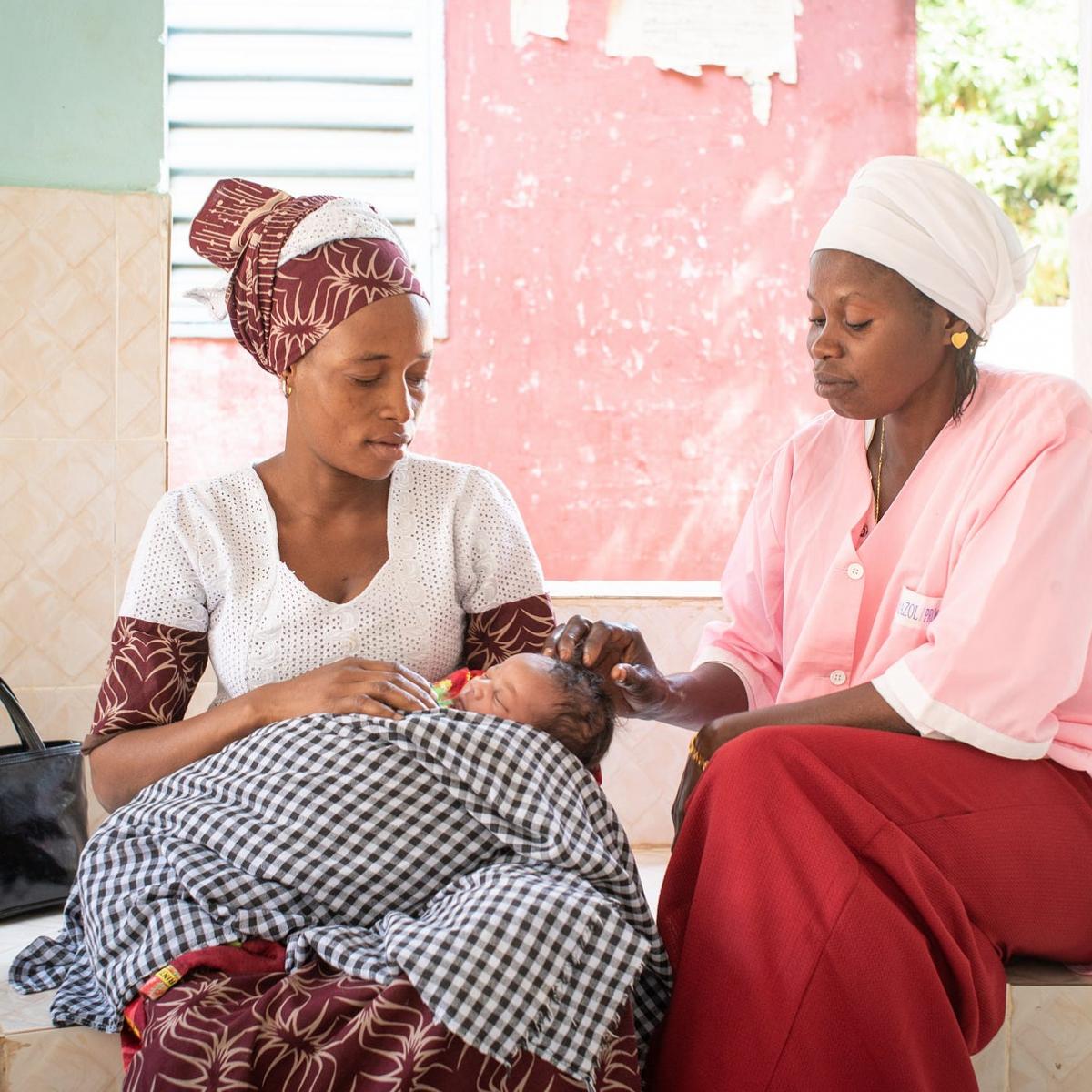 Djiba Balde sits with her child, Aissatou Balde, and the matron Penda Balde, after a consultation in the health center of Sarre Bilaly in the Kolda region, Senegal.