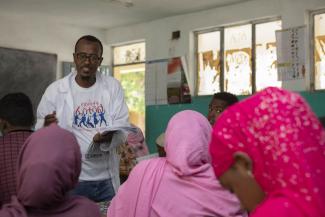 A young man from Kefeta, one of USAID's implementing partners, talks to students in a classroom in Dire Dawa, Ethiopia. 