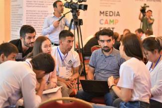 A group of journalists sitting in a circle and talking during a MediaCAMP event