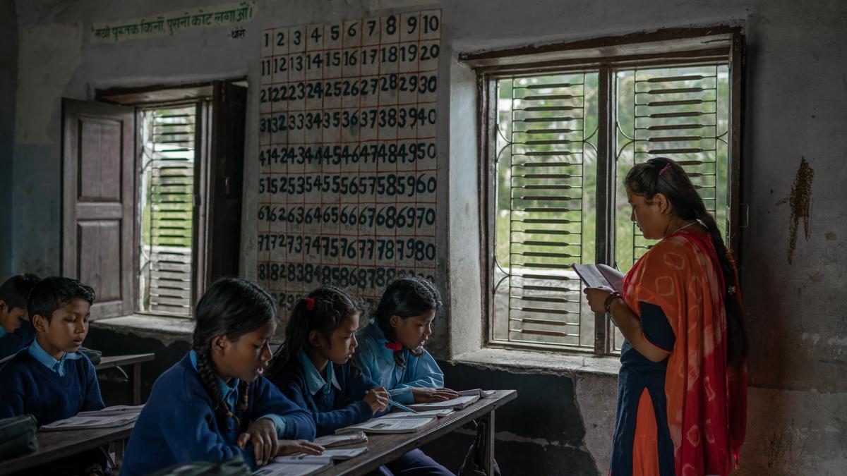 Woman standing in front of students sitting in a classroom.