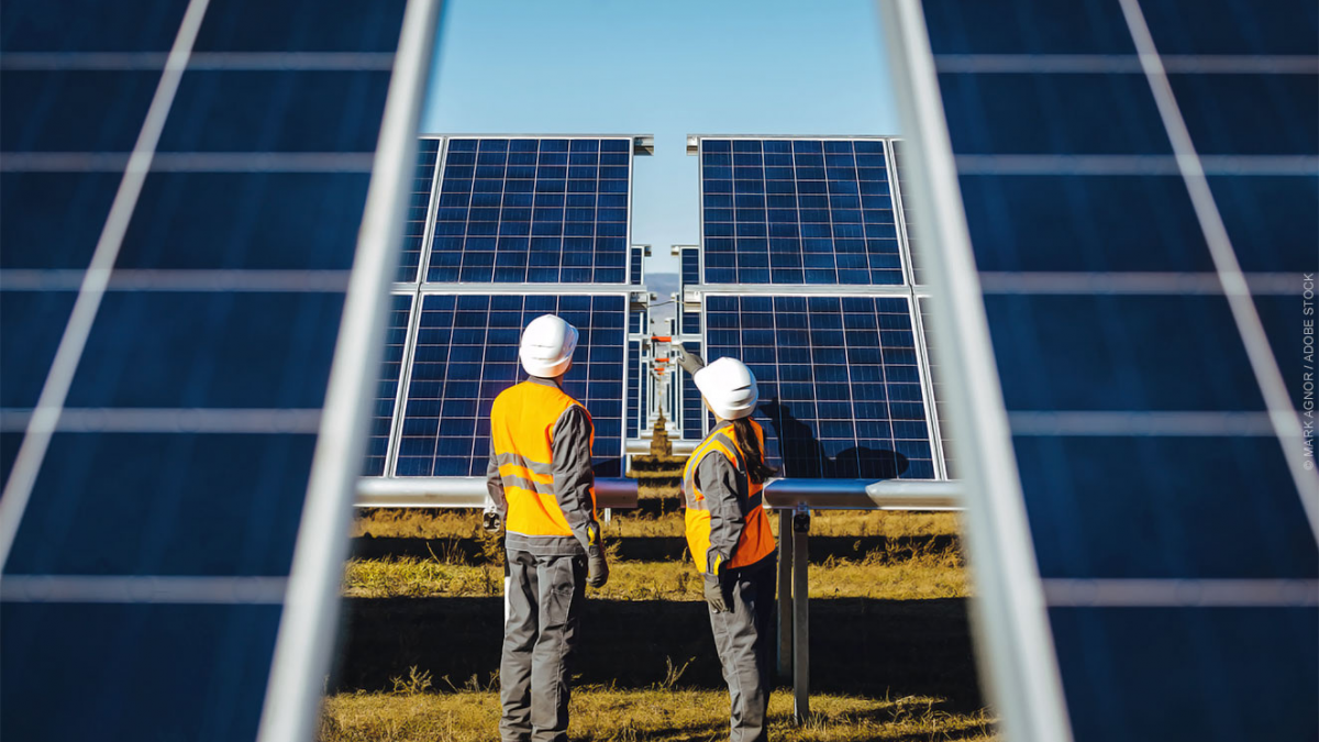 Two technicians inspect solar panels