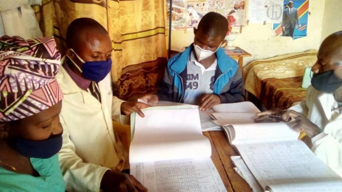Doctors review HIV testing registers and client files at the alternative medicine center (AMC) in the Democratic Republic of Congo through a PATH-led Integrated HIV/AIDS Project to decentralize HIV treatment and care outside health facilities.
