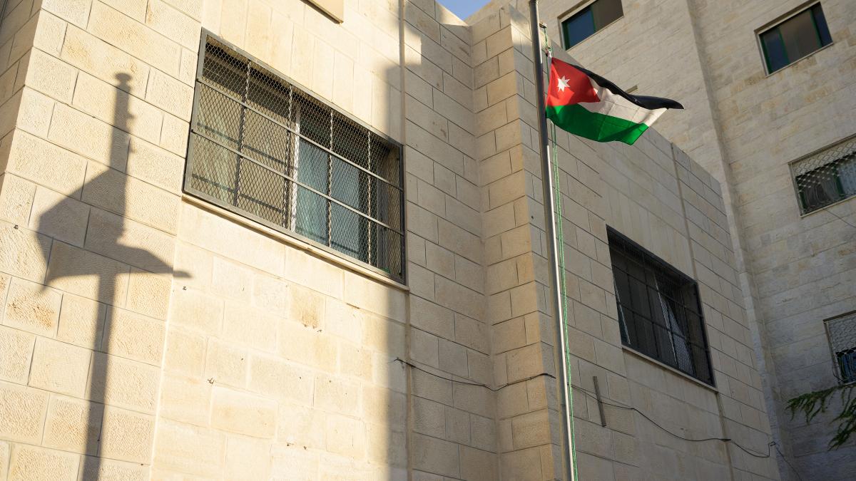 The Jordanian national flag flies outside of a school.