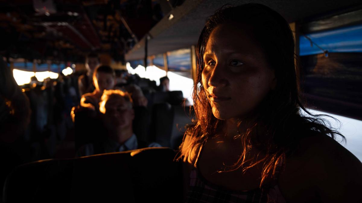 A woman sitting on a crowded bus.