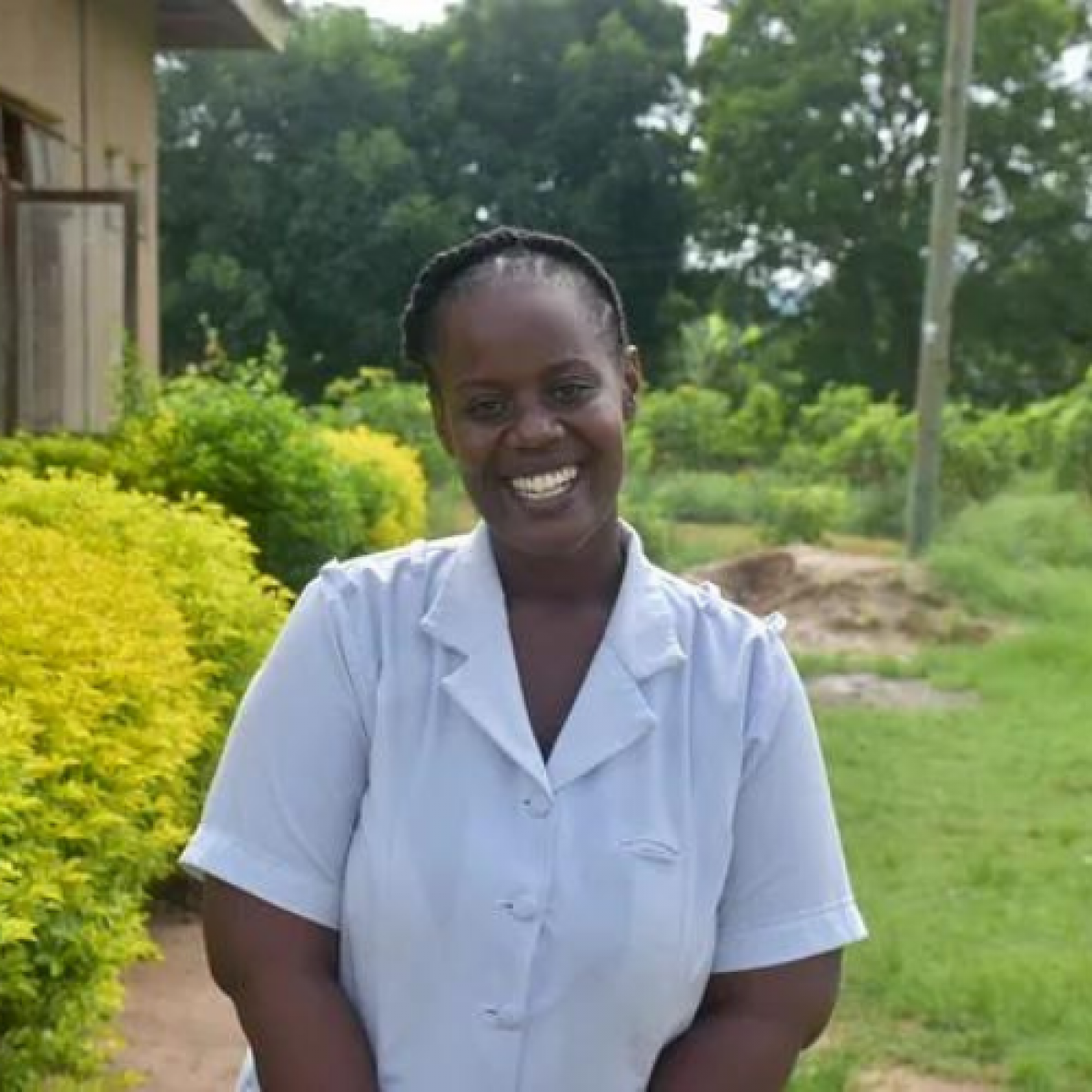 Nurse Isabella Hwinzela Bigendako stands outside the health facility where she works in Morogoro, Tanzania.