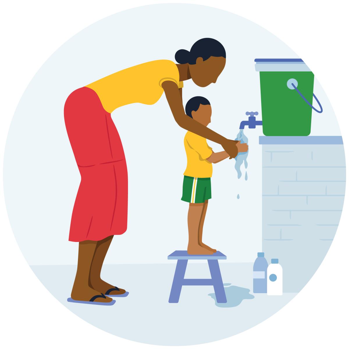 A mother helps her young child wash their hands at a handwashing station. 