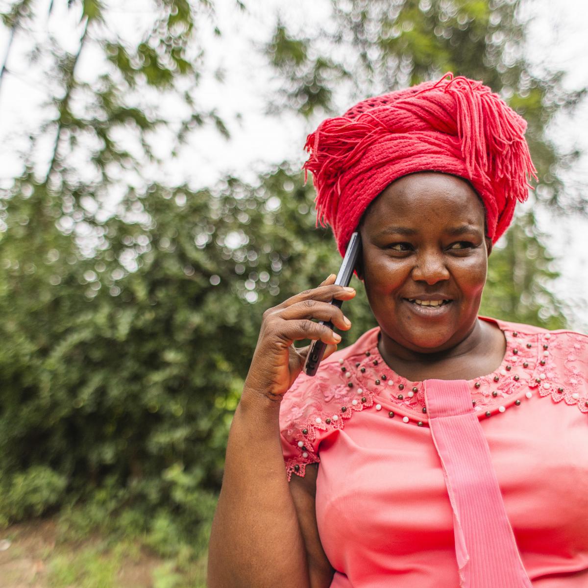 A woman holds a smartphone up to her ear.