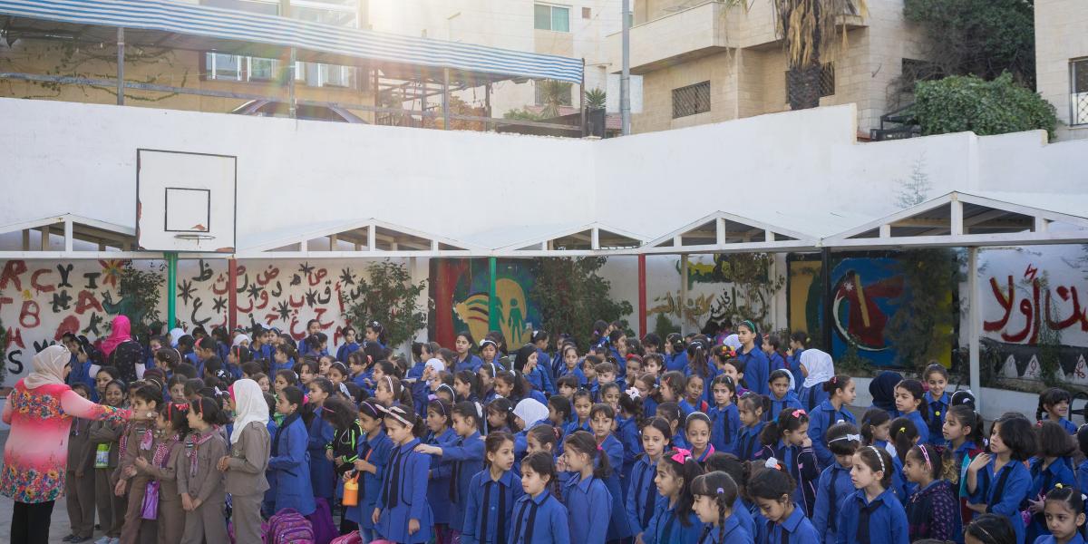 A group of school children congregate.