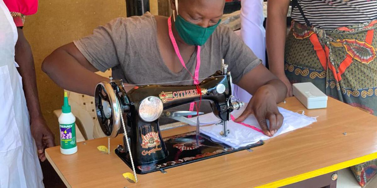 Woman at sewing machine for NPI’s EXPAND Project