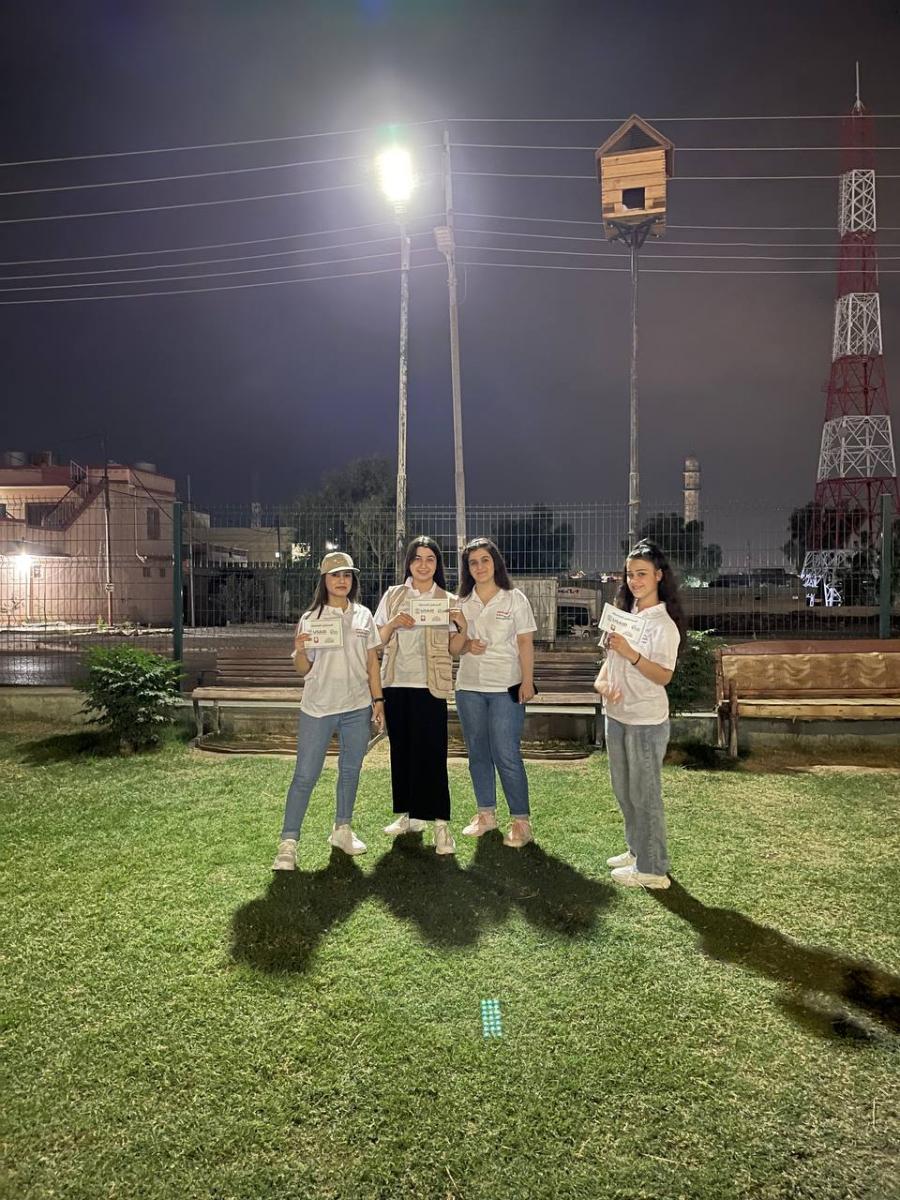 Ghalia Sliman and other young women who participated in Shared Future stand in front of a solar powered street light they installed