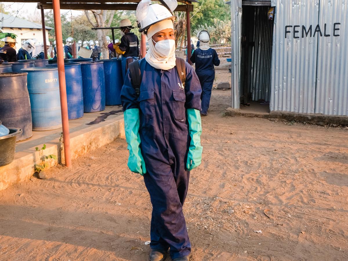 Theresa Phiri, an indoor residual sprayer, stands in her full gear.