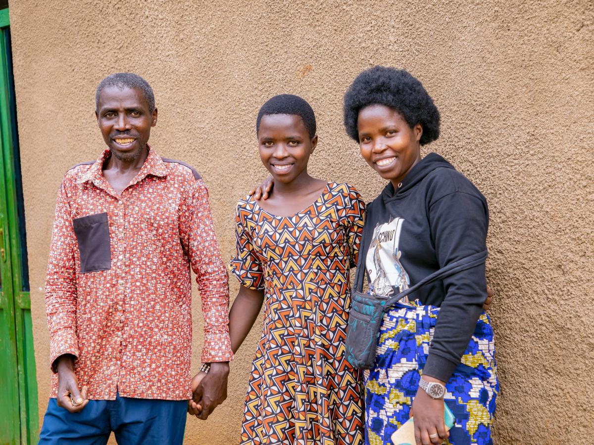 Noel, Teta and Beatrice in front of their home in Rwanda.