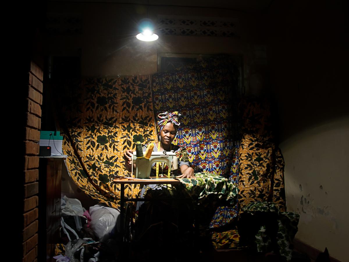 An African seamstress working under a bring light