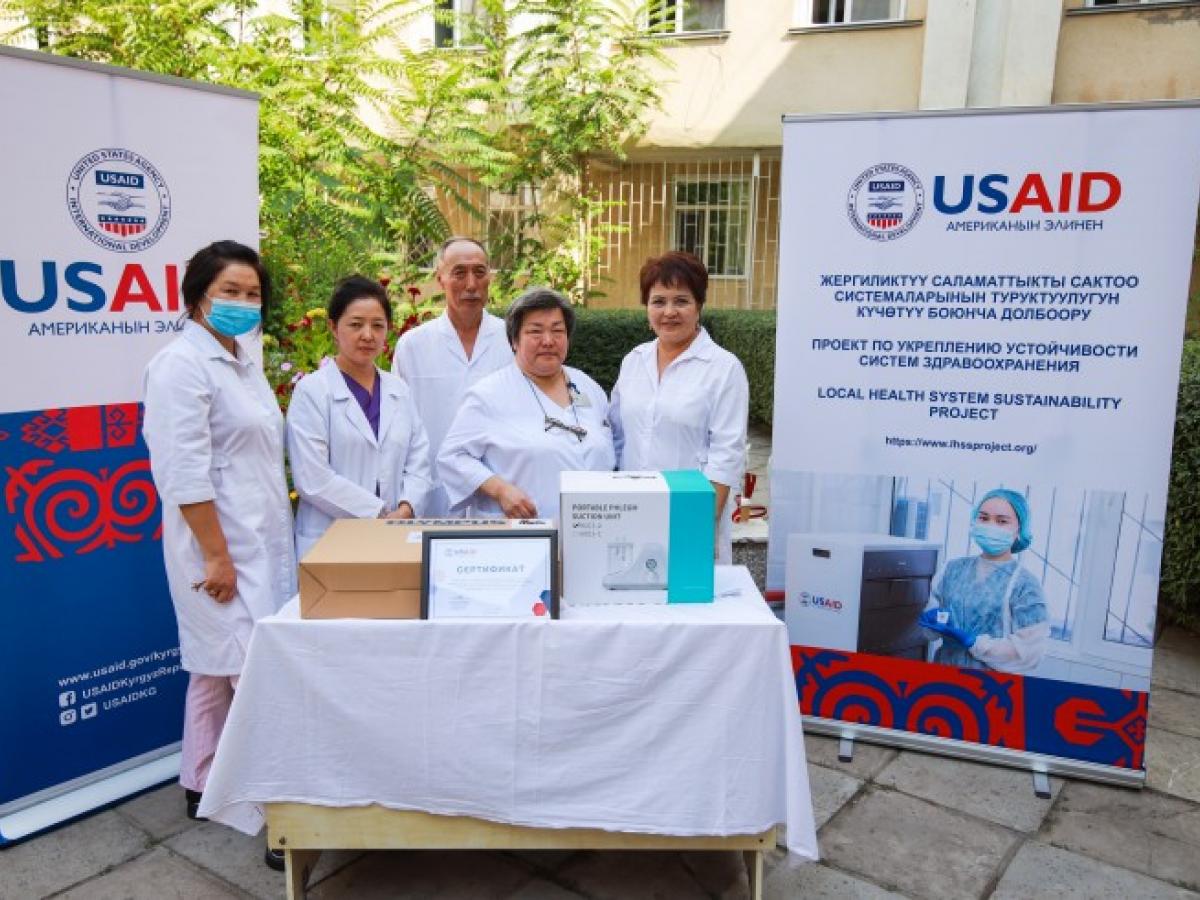 Health practitioners standing at a table with USAID donated medical supplies