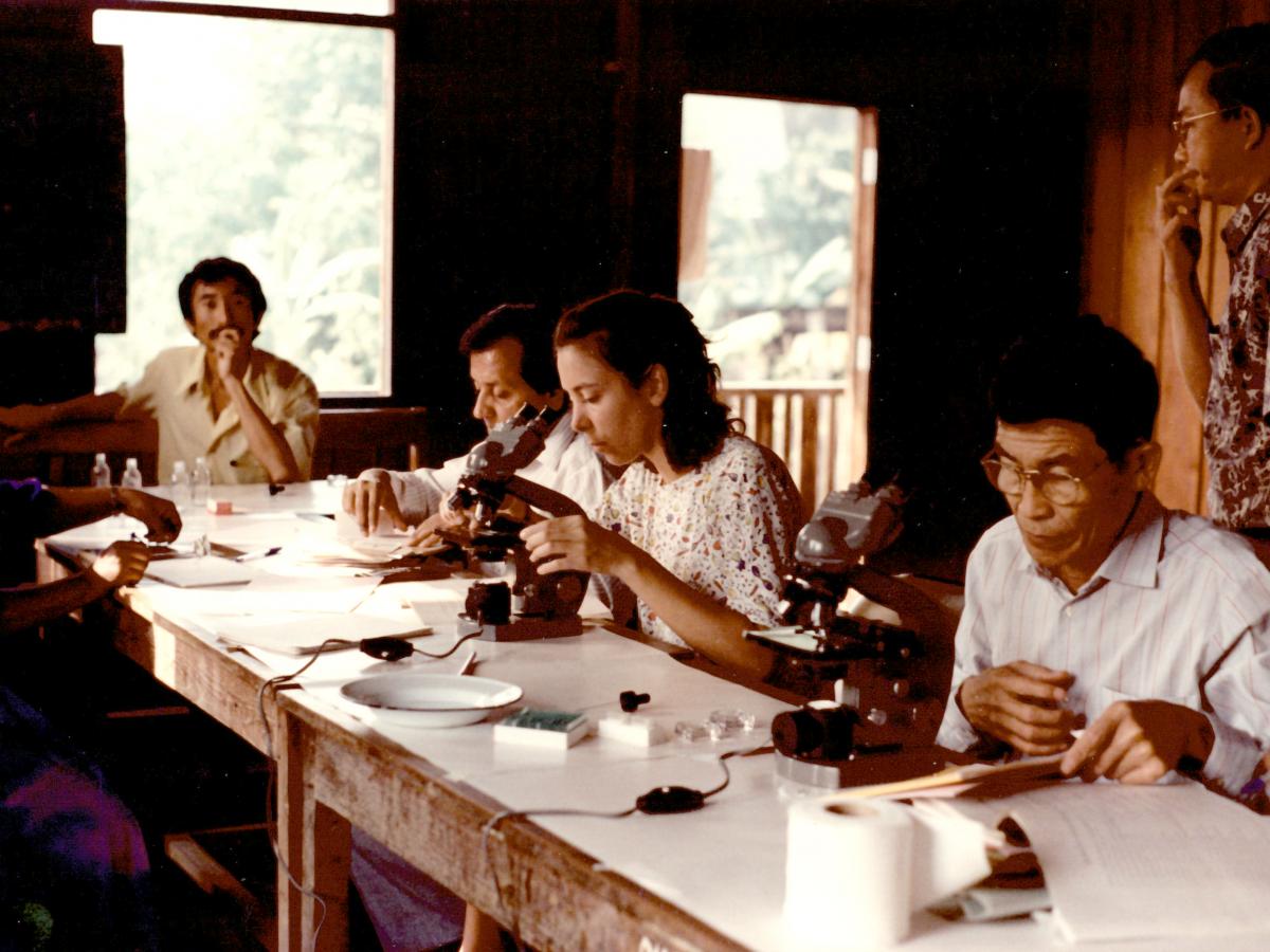 Blood examination for malaria parasites diagnosis at the Malaria Training Center in Praputhabat district, Sarak Bori province, Thailand, in 1991. Mr. Chheang is on the right.
