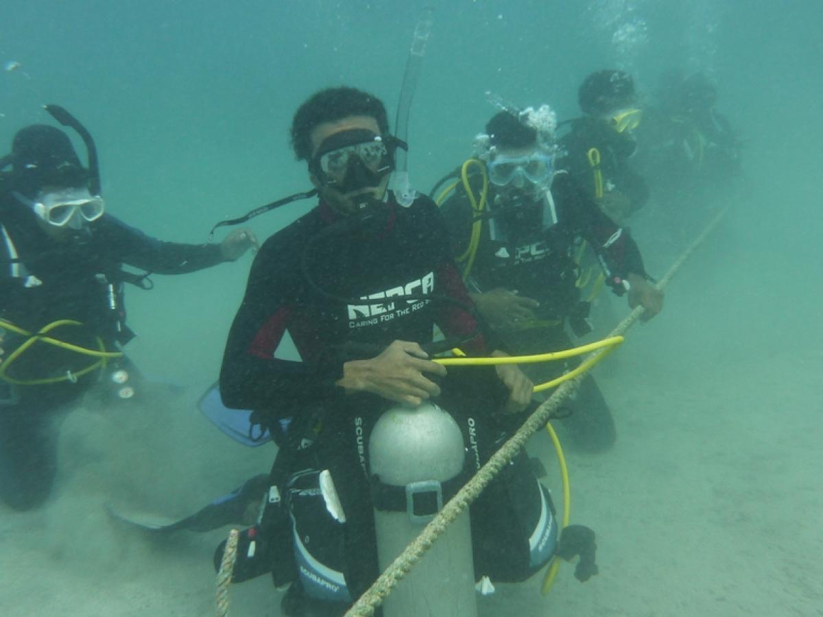 A scuba diving crew works underwater on the installation of the mooring system in the Red Sea.