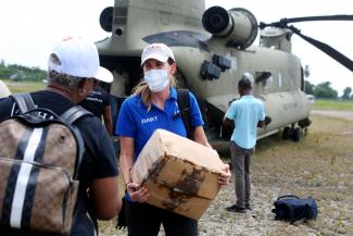 A member of the USAID DART helps load humanitarian supplies on a JTF-Haiti helicopter. At the request of the DART, JTF-Haiti is airlifting supplies and equipment for NGOs operating in hard-hit areas. 