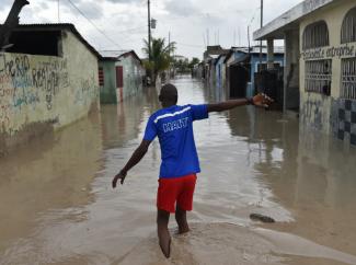 A man walks down a flooded street in the Haitian Capital Port-au-Prince