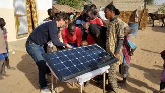 In the eco-village of Yeuma, Senegal, Little Sun Founder Frederik Ottesen and Yeuma residents install a prototype of the Little Sun community solar mobile phone charger, large enough to serve the charging needs of an entire village.