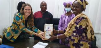 Mrs. Amy Diallo, Director of USAID Guinea Health Office (left), officially hands over the equipment to members of the National Institute of Public Health.