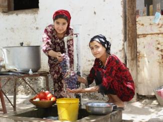 Sadbarg and her friend washing fruits at the new water tap in their home