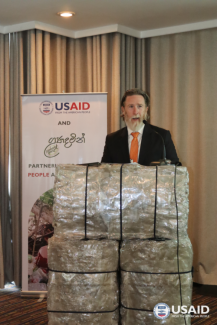 Christopher Powers, Director – Office of Economic Growth, USAID Sri Lanka and Maldives Mission standing behind a podium crafted from baled plastic bottles.