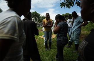 A woman speaks to a group of mourners