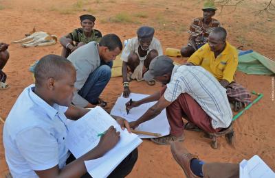 Men in a rural African community drawing maps of local resources