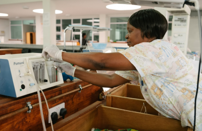 A nurse attends to medical equipment in a hospital.