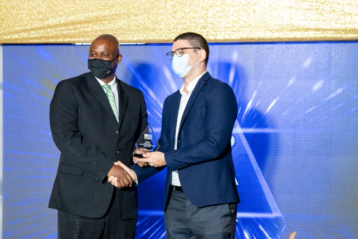 Jason Fraser (l), USAID Country Representative, presents The Spotlight Award to Dr. Geoffrey Barrow (r), Director Health Connect Jamaica, during the 2021 USAID Stakeholder Appreciation & Recognition Awards. Credit: Dr. Geoffrey Barrow