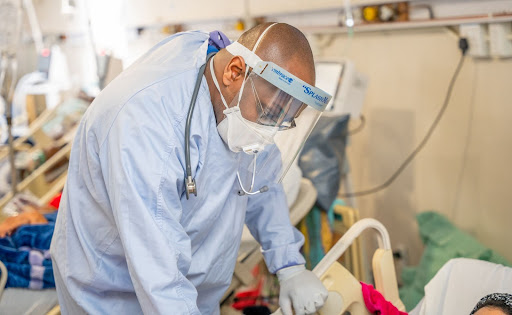 Dr. Elton examining a critically ill individual admitted for COVID-19.