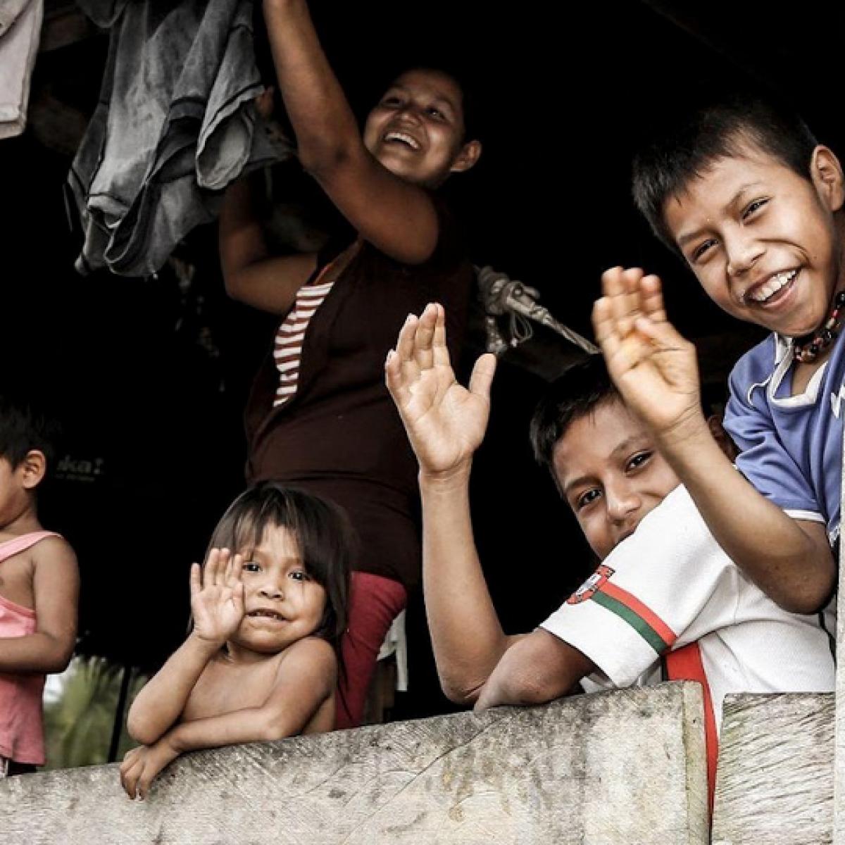 A group of children laughing in a cottage in the Amazon region