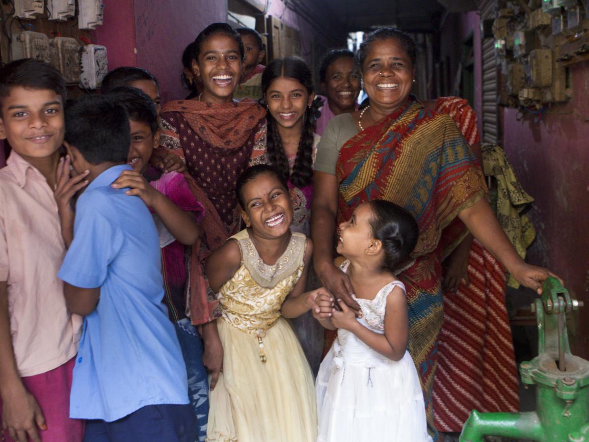 2023 Gender Policy - A group of women and children smile for the camera
