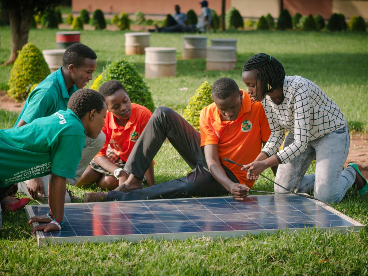 Students sitting around a solar panel