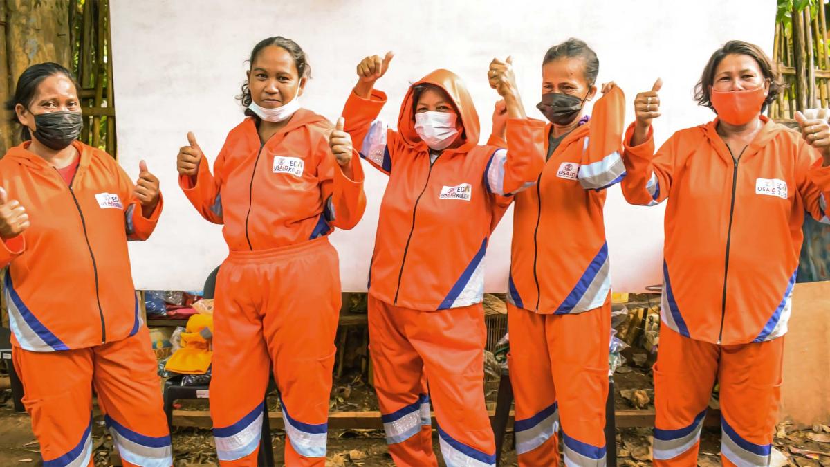 Five cheering women wearing orange uniforms