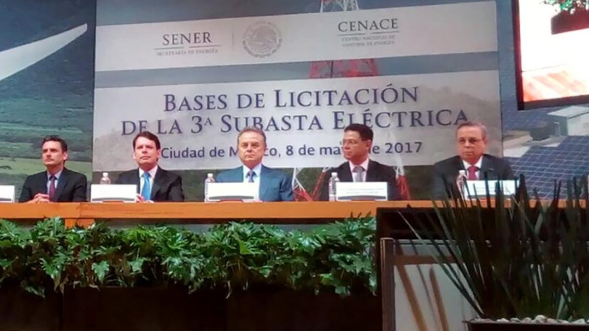 A row of Mexican energy officials sit at a dias for the presentation of auction rules