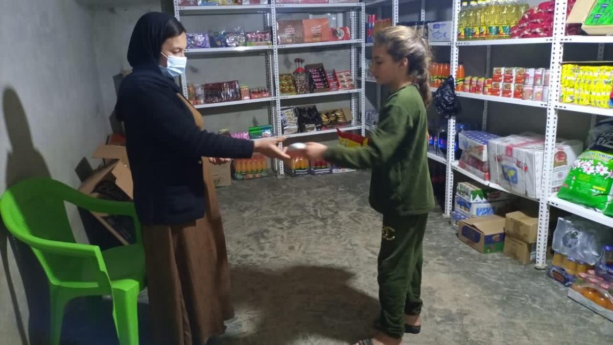 Naleen makes her first sale in her new mini-market located in Kobarto 1 Camp in Duhok.