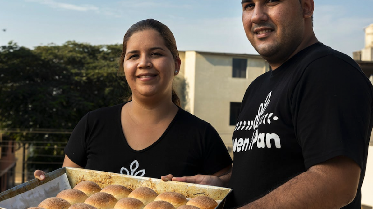 A couple of venezuelan entreprenuers holding a plate with baked bread