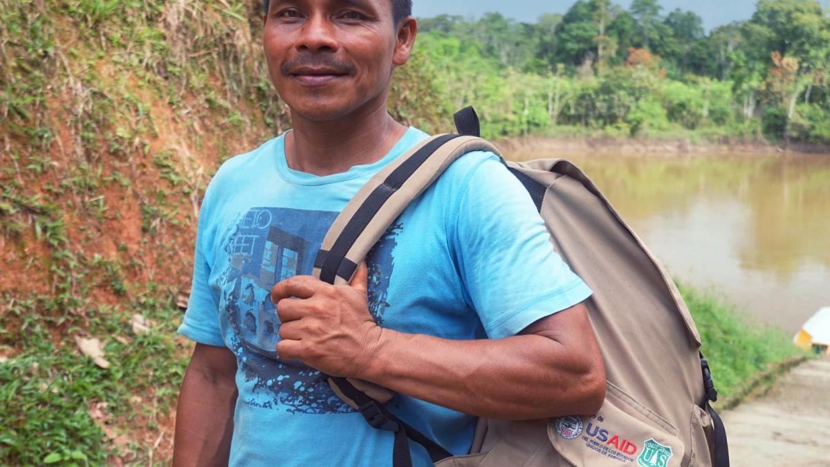 An indigenous man holding the Forest Backpack
