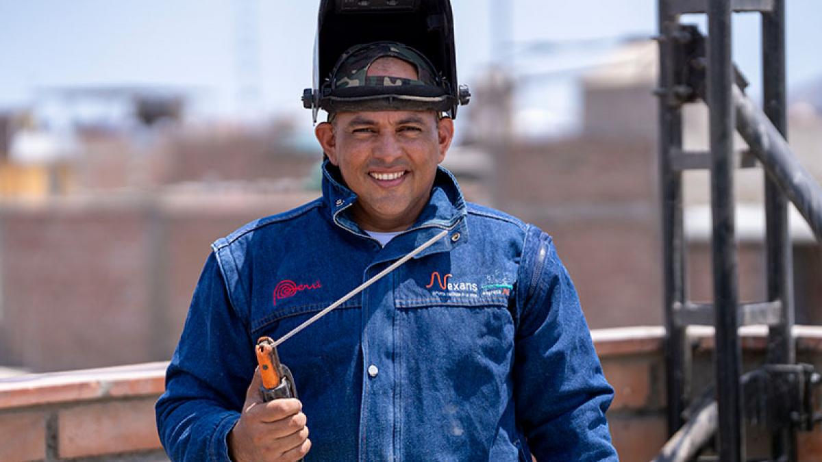 A worker man smiling and holding a welding tool