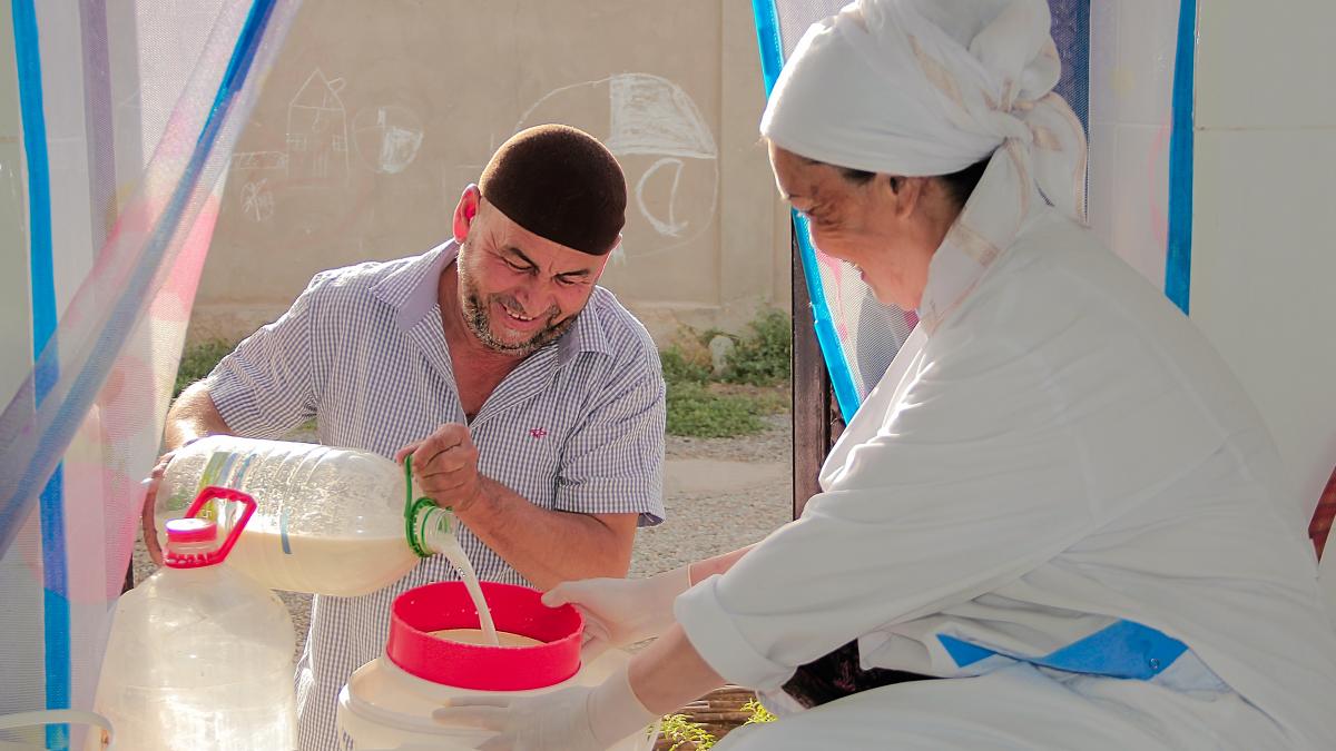 Uguloy Abdullaeva while receiving milk from citizens. Balkhi district, June 2022.