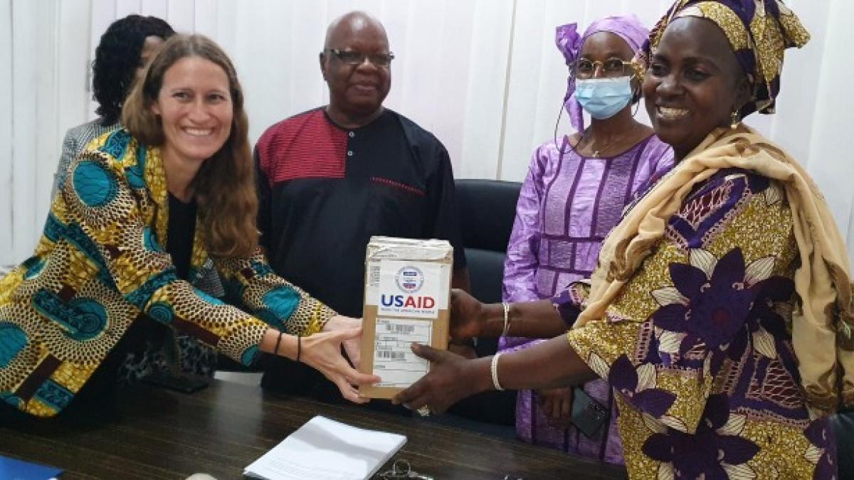 Mrs. Amy Diallo, Director of USAID Guinea Health Office (left), officially hands over the equipment to members of the National Institute of Public Health.