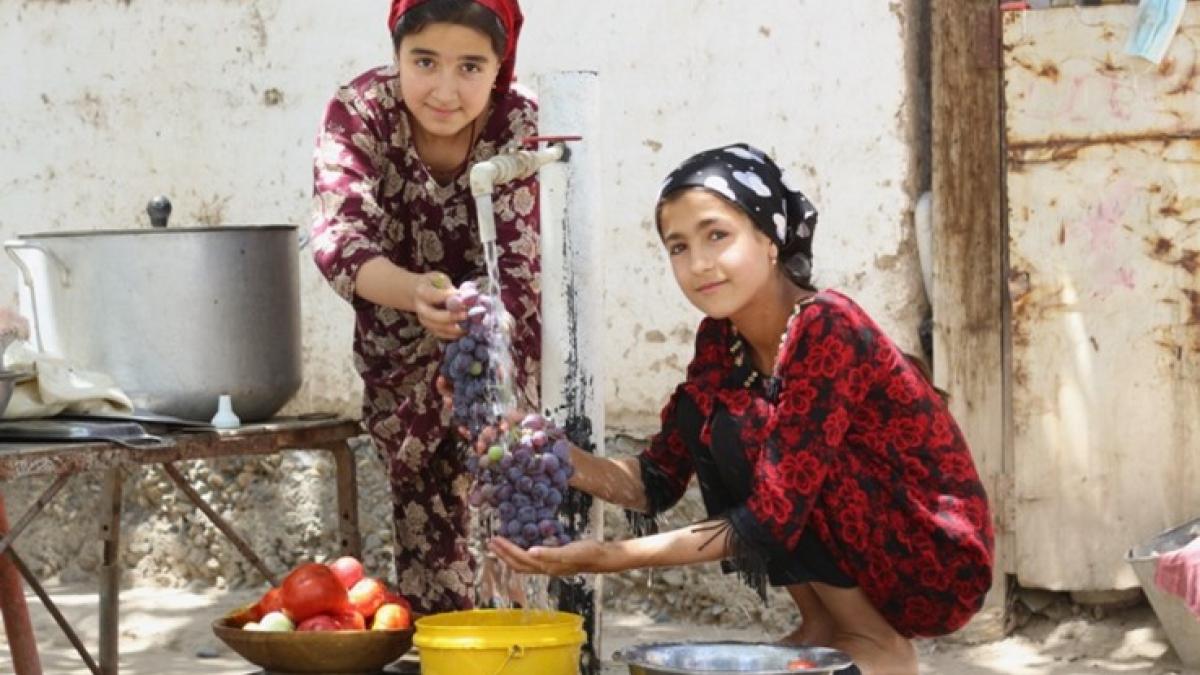 Sadbarg and her friend washing fruits at the new water tap in their home.