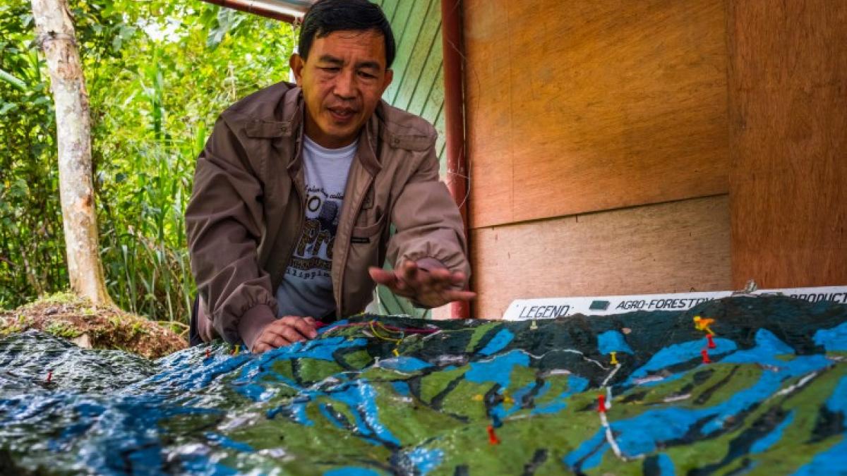 Community member David Marcelo helps to lead the Natural Resources Development Program of the Kalahan Educational Foundation in the Philippines. Here, he discusses land management over time using a handcrafted map.